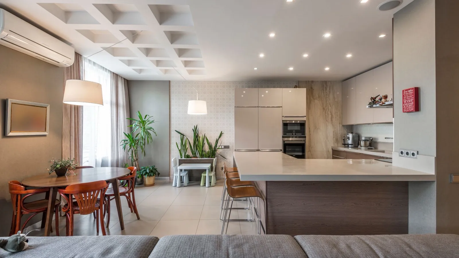 Best DIY multi zone cassette mini split 2026 — an open-plan home with living, dining, and kitchen zones under a coffered ceiling, cooled by a ductless mini split indoor unit