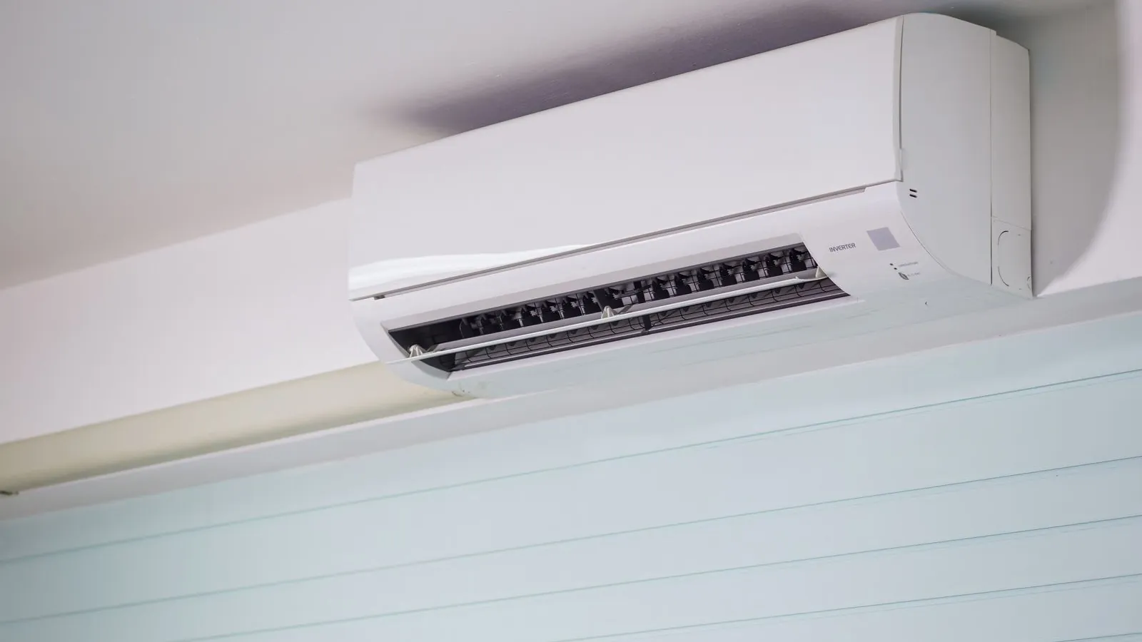 12000 BTU DIY mini split system review 2026: white wall-mounted ductless mini split indoor unit mounted high on a light blue wall