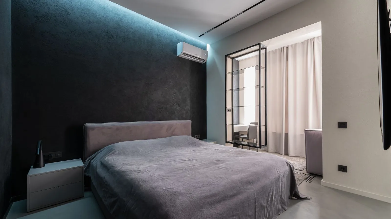 Best DIY mini split for a bedroom: a 9,000 BTU white wall-mounted ductless mini split head installed high on the wall above the bed in a modern bedroom