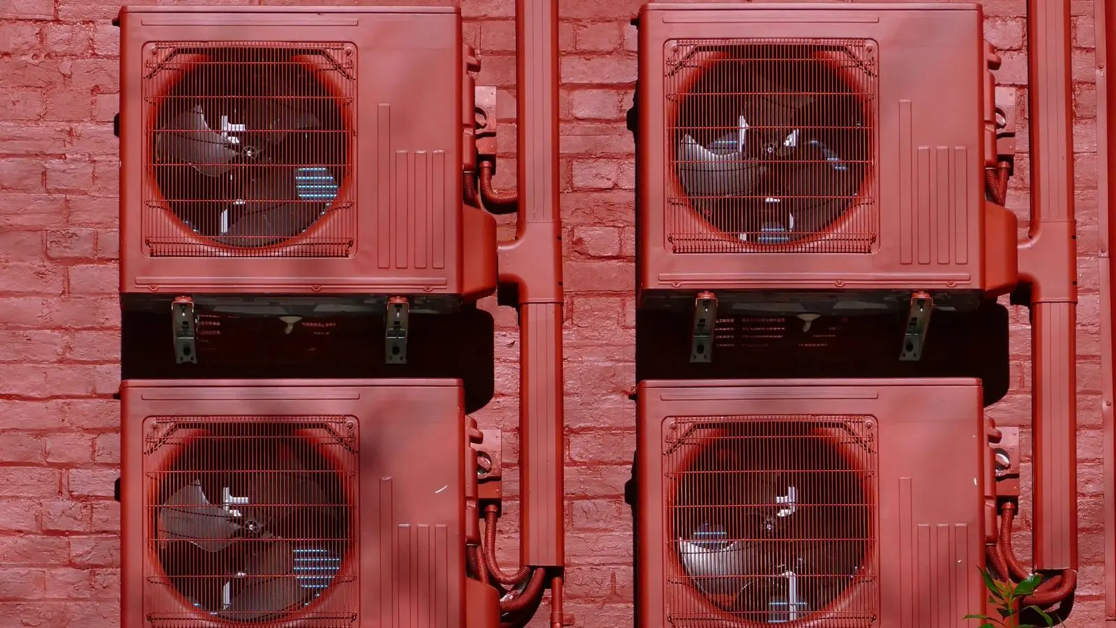 Best quick connect mini split 2026: four ductless mini split outdoor condensers wall-mounted on a red brick wall with their line set covers running beside them